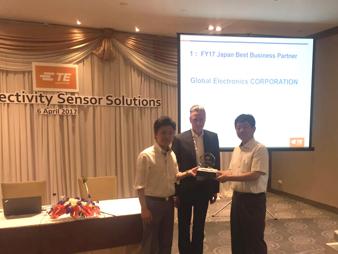 センサ事業部の松田（右）と大阪営業所の木谷（左）が TE Sensor Solutions の Myers 氏（中央）から「ベスト ジャパン パートナー賞」を受け取りました